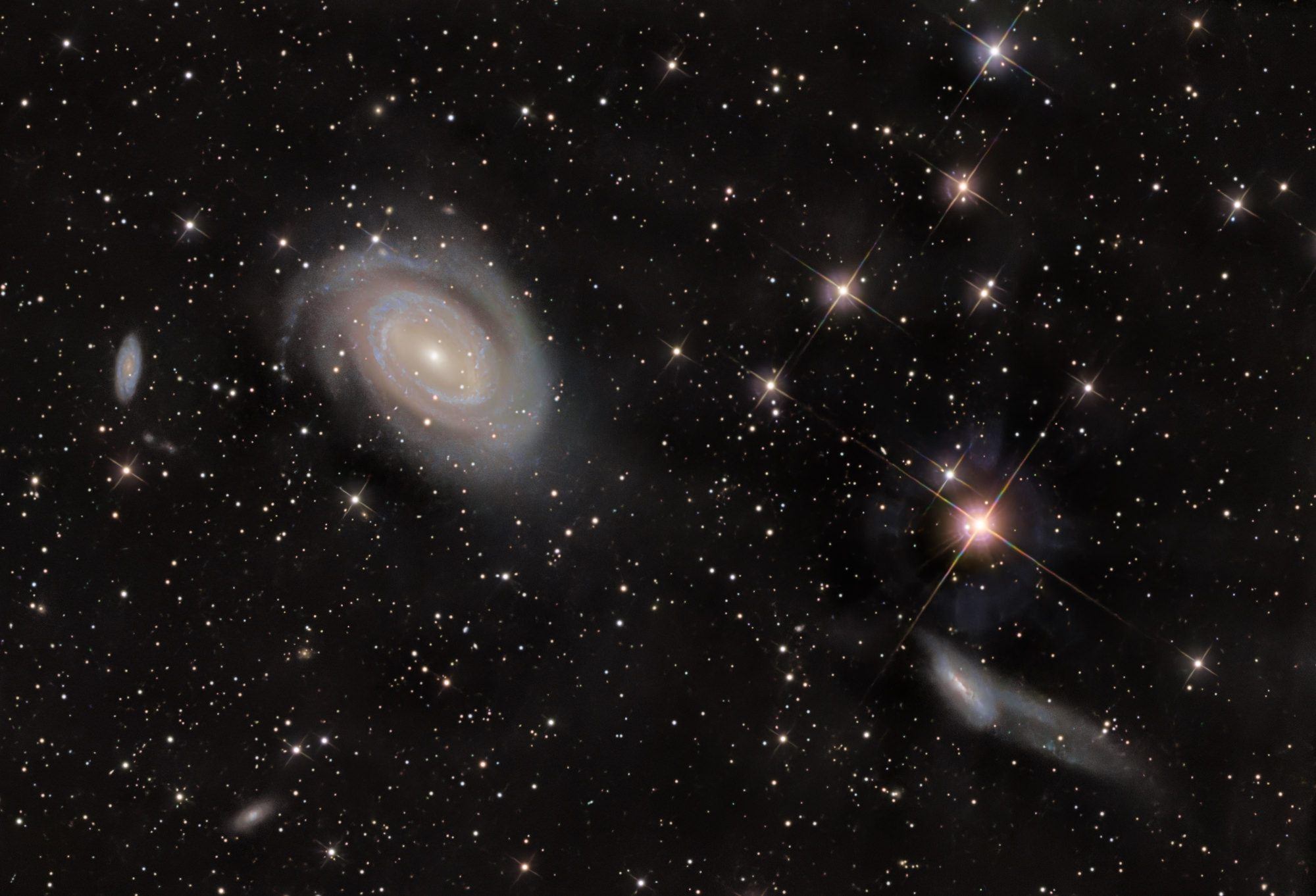 Das Holmberg-468-Galaxientriplett im Sternbild Coma Berenices enthält von links nach rechts die Galaxien NGC4712, NGC4725 und NGC4747. Die große Galaxie NGC 4725 interagiert mit der benachbarten Galaxie NGC 4747 rechts unten im Bild und besitzt ein extrem massereiches Schwarzes Loch im Zentrum.
